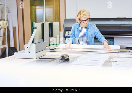 Jeune femme travaillant dans Printshop Banque D'Images