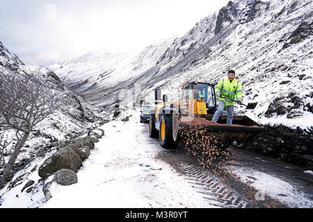 Un tracteur efface la neige d'une route près de Honister Mine d'ardoise dans le Lake District, Cumbria, comme les navetteurs face au verglas le lundi matin, avec de fortes chutes de neige attendues dans certaines parties de l'Écosse alors de véhicules devenir bloqués sur les routes. Banque D'Images