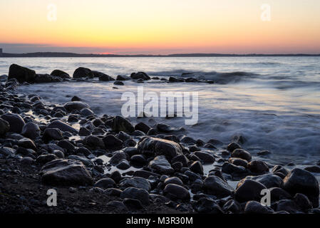 Coucher du soleil à une plage rocheuse, dans le nord de l'Allemagne, Lübeck, Schleswig-Holstein Banque D'Images