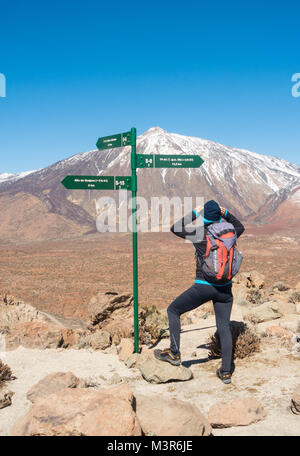 Female hiker avec superbe vue sur El Teide couvert de neige à partir de la Degollada de films (titres en parc national de Teide à Tenerife, Îles Canaries, Espagne Banque D'Images