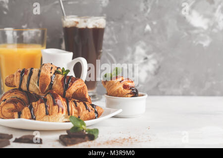 Petit-déjeuner frais composé de croissants avec du sirop de chocolat, jus d'orange et de cacao avec marshmelow. Banque D'Images