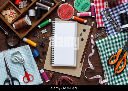 Mise à plat de l'image aérienne styliste de mode arrière-plan articles concept.vue d'en haut ou d'accessoires de couture sur l'équipement sur mesure en bois brun rustique moderne à la maison Banque D'Images