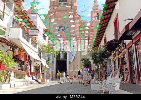 Papel picado drapeaux volent au-dessus de la rue piétonne menant à l'emblématique Église de Notre Dame de Guadalupe à Puerto Vallarta, au Mexique. Banque D'Images