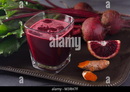 Le jus de betterave bio frais avec d'Orange Sanguine et de racine de Curcuma Banque D'Images