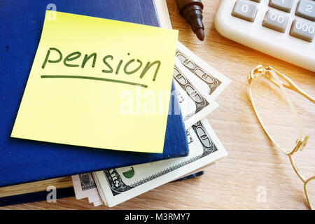 Écrit Pension sur un bâton et de l'argent dans le livre. L'épargne-retraite. Banque D'Images