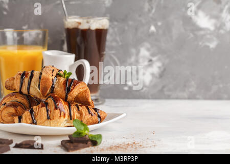 Petit-déjeuner frais composé de croissants avec du sirop de chocolat, jus d'orange et de cacao avec marshmelow. Banque D'Images