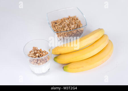 Ingrédients pour l'avoine fait maison dans un bocal en verre de granola. Flocons d'avoine, le miel, les raisins secs et les noix. Petit-déjeuner sain concept avec copie espace. Banque D'Images