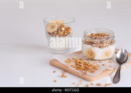 Ingrédients pour l'avoine fait maison dans un bocal en verre de granola. Flocons d'avoine, le miel, les raisins secs et les noix. Petit-déjeuner sain concept avec copie Banque D'Images