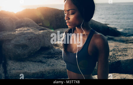 Femme fitness fatigué se reposant après l'exercice en plein air. Jeune femme en bonne santé de sueur article en plein air après une intense séance de formation. Banque D'Images
