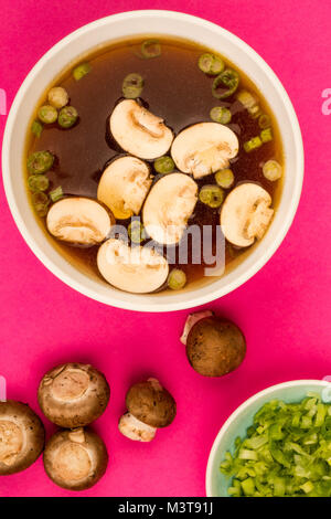 Bol de soupe claire de style japonais avec des champignons et oignons de printemps Banque D'Images