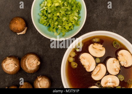 Bol de soupe claire de style japonais avec des champignons et oignons de printemps Banque D'Images