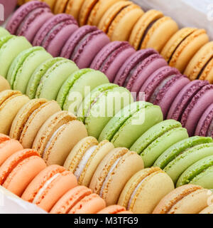 Multi-couleur ronde de délicieux biscuits faits à la main sont empilés dans une rangée dans une boîte Banque D'Images