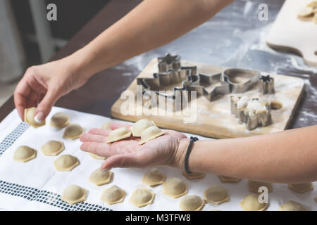 Le processus de faire de délicieux raviolis faits maison. Les mains des femmes est la pose des boulettes faites juste sur la table Banque D'Images