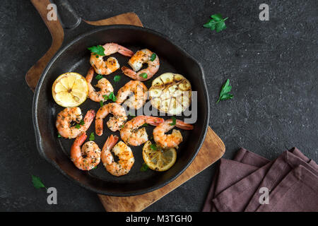 Crevettes grillées avec du citron, l'ail et fines herbes. Fruits de mer, de bivalves. Crevettes crevettes grillées aux épices, ail et citron sur fond de pierre noire, copie Banque D'Images