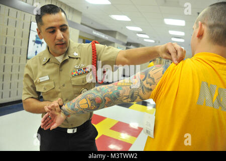 170125-N-SL853-057 GRANDS LACS, Illinois (janv. 31, 2017) 1ère classe veteran du navire Juan Diazangulo inspecte les tatouages d'une recrue à bord de recruter le commandement de l'instruction. Environ 400 nouvelles recrues arrivent chaque semaine à la marine est que boot camp. (U.S. Navy Photo de Susan Krawczyk/libérés) 170125-N-SL853-057 par conservateur Photographie Banque D'Images