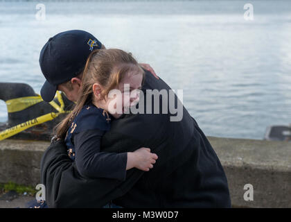 BANGOR, Washington (21 mars 2017) Directeur Logistique Kyle Bryant, spécialiste de Lowell, Massachusetts, attribué à l'équipage d'or de la classe Ohio-balistique sous-marin SNLE USS Nevada (733), embrasse sa fille alors que le bateau retourne à base navale Kitsap-Bangor à la suite d'une patrouille de routine de dissuasion stratégique. Le Nevada est l'un des huit sous-marins des missiles balistiques stationnés à la base offrant le plus de chance de survie de la triade de dissuasion stratégique pour les États-Unis. (U.S. Photo par marine Spécialiste de la communication de masse 1re classe Amanda R. Gray/libérés) 170321-N-UD469-088 par Naval Base Kitsa Banque D'Images