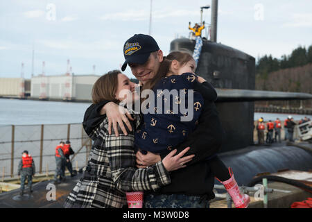 BANGOR, Washington (21 mars 2017) Directeur Logistique Kyle Bryant, spécialiste de Lowell, Massachusetts, attribué à l'équipage d'or de la classe Ohio-balistique sous-marin SNLE USS Nevada (733), embrasse sa famille comme le bateau retourne à base navale Kitsap-Bangor à la suite d'une patrouille de routine de dissuasion stratégique. Le Nevada est l'un des huit sous-marins des missiles balistiques stationnés à la base offrant le plus de chance de survie de la triade de dissuasion stratégique pour les États-Unis. (U.S. Photo par marine Spécialiste de la communication de masse 1re classe Amanda R. Gray/libérés) 170321-N-UD469-095 par Naval Base Kitsap Banque D'Images