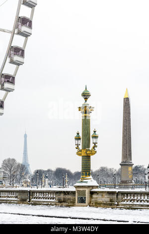 L'hiver à Paris dans la neige. Place de la Concorde couverts dans la neige avec une colonne rostrale, l'obélisque de Louxor, la grande roue et la tour Eiffel. Banque D'Images