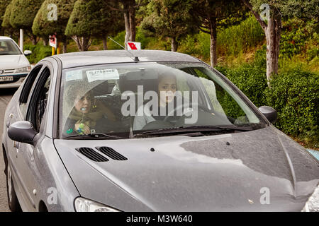 Téhéran, Iran - 28 Avril 2017 : femme iranienne en hijab durs voiture près de parc. Banque D'Images