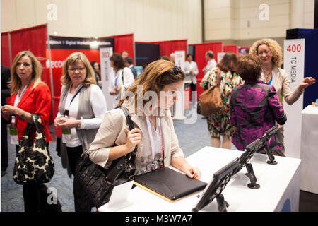 Une femme vérifie sur un stand pendant les vendeurs l'Art du Marketing Conference à Toronto, Ontario, Canada le mercredi, Juin 05, 2013. La conférence a accueilli des conférenciers et fournisseurs orientés vers la nouvelle ère du marketing, y compris conférencier Biz Stone, co-fondateur et directeur créatif de Twitter. Banque D'Images