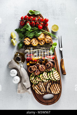 Un grand plateau en bois avec un snack d'été, barbecue coloré de légumes, tomates cerises et verts. été délicieux aliments sains pour une grande entreprise de Banque D'Images