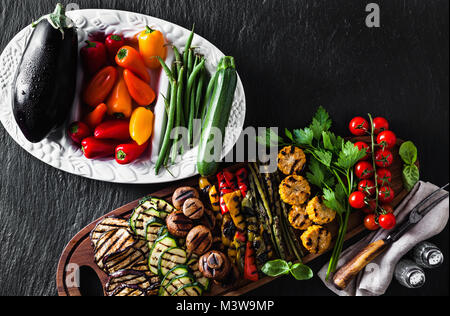 Un grand plateau en bois avec un snack d'été, barbecue coloré de légumes, tomates cerises et verts. été délicieux aliments sains pour une grande entreprise de Banque D'Images