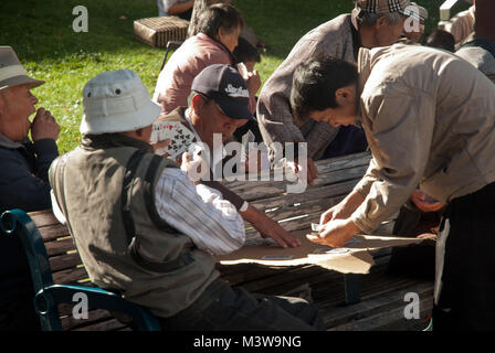 Les hommes chinois de cartes à jouer sur un banc dans un parc de San Francisco, Californie Banque D'Images