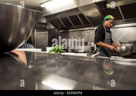 Un chef cuisinier travaillant sur ses pieds dans une cuisine de restaurant à Bristol, Angleterre Banque D'Images