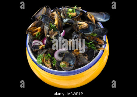 Moule bleue française avec des herbes dans un jaune. Des fruits de mer en fond noir Banque D'Images