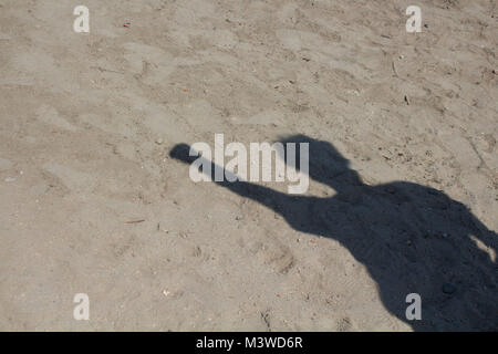 Ombre de l'homme faisant signer sur fond de sable le socialisme. Yannick Noah est un symbole de solidarité et de soutien. Il est également utilisé comme un hommage à l'unité express Banque D'Images