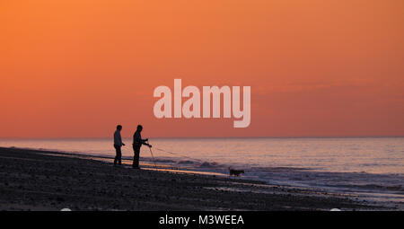 Trois amis sur la plage au coucher du soleil . Banque D'Images