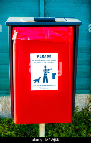 Situé à l'extérieur du bac rouge vif pour les excréments de chien, avec une lecture de l'étiquette : "Veuillez être un propriétaire de chien responsable. Nettoyer après votre chien." L'Angleterre, Royaume-Uni. Banque D'Images