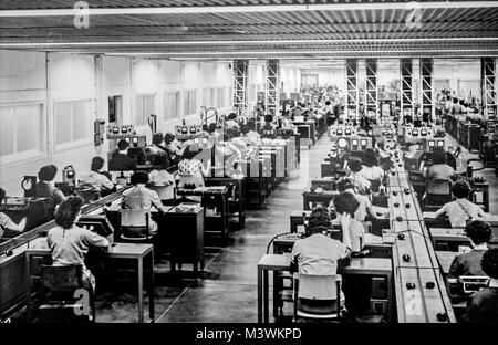 Archives anciennes en noir et blanc photographie montrant les travailleuses des petits moteurs électriques de fabrication en usine dans les années 1950 Banque D'Images