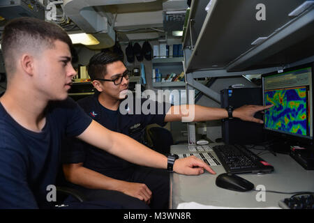 Le Golfe Arabique (Aug. 6, 2017) La Marine américaine'Aérographe 4400 2e classe Erwin Begay, droite, de Phoenix, l'Aviateur de Dylan Eaton, trains de Colorado Springs, Colorado, sur la façon de lire les rapports du vent de haut niveau à bord du porte-avions USS Nimitz (CVN 68), le 6 août 2017, dans le golfe Arabo-Persique. Nimitz est déployée dans la 5e flotte américaine zone d'opérations dans le cadre de l'opération inhérents résoudre. Alors que dans cette région, le navire et d'attaque mènent des opérations de sécurité maritime pour rassurer les alliés et les partenaires, de préserver la liberté de navigation, et de maintenir la libre circulation du commerce. (U.S. Photo par Marine Banque D'Images