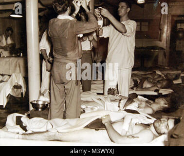 80-G-31359 : Campagne de Guadalcanal, Août 1942-février 1943. L'homme blessé dans la bataille de l'île de Tulagi, 7-8 août 1942, portées à bord de l'USS Neville (AP-16). Photographie de la Marine américaine officielle, aujourd'hui dans les collections des Archives nationales. (2018/01/24). 80-G-31359 o  39168584574 Banque D'Images