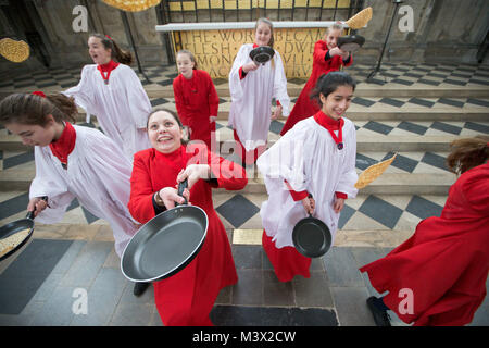 Les Choristes à partir de la cathédrale d'Ely dans le Cambridgeshire pratiquer pour ce qui est de la course de crêpes années lieu le Mardi Gras ( Feb 13) dans la cathédrale. Les Choristes ont été occupés à pratiquer pour la traditionnelle course de crêpes à la Cathédrale d'Ely dans le Cambridgeshire demain (mardi). Les filles, vêtus de leurs soutanes rouges, perfectionné leurs compétences pour lancer de crêpes l'événement annuel dans la Cathédrale du xiie siècle. Chaque année autour de 20 choristes de la Boys' and Girls' choirs dévalez la nef après la messe à l'occasion de Mardi Gras. Il est le troisième plus long nef au Royaume-Uni, mesure 75 mètres. Banque D'Images