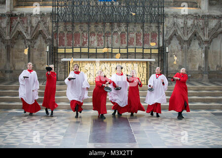 Les Choristes à partir de la cathédrale d'Ely dans le Cambridgeshire pratiquer pour ce qui est de la course de crêpes années lieu le Mardi Gras ( Feb 13) dans la cathédrale. Les Choristes ont été occupés à pratiquer pour la traditionnelle course de crêpes à la Cathédrale d'Ely dans le Cambridgeshire demain (mardi). Les filles, vêtus de leurs soutanes rouges, perfectionné leurs compétences pour lancer de crêpes l'événement annuel dans la Cathédrale du xiie siècle. Chaque année autour de 20 choristes de la Boys' and Girls' choirs dévalez la nef après la messe à l'occasion de Mardi Gras. Il est le troisième plus long nef au Royaume-Uni, mesure 75 mètres. Banque D'Images