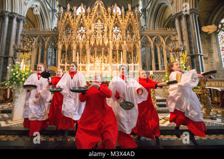 Les Choristes à partir de la cathédrale d'Ely dans le Cambridgeshire pratiquer pour ce qui est de la course de crêpes années lieu le Mardi Gras ( Feb 13) dans la cathédrale. Les Choristes ont été occupés à pratiquer pour la traditionnelle course de crêpes à la Cathédrale d'Ely dans le Cambridgeshire demain (mardi). Les filles, vêtus de leurs soutanes rouges, perfectionné leurs compétences pour lancer de crêpes l'événement annuel dans la Cathédrale du xiie siècle. Chaque année autour de 20 choristes de la Boys' and Girls' choirs dévalez la nef après la messe à l'occasion de Mardi Gras. Il est le troisième plus long nef au Royaume-Uni, mesure 75 mètres. Banque D'Images