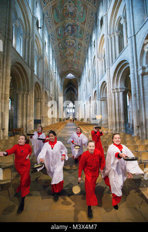 Les Choristes à partir de la cathédrale d'Ely dans le Cambridgeshire pratiquer pour ce qui est de la course de crêpes années lieu le Mardi Gras ( Feb 13) dans la cathédrale. Les Choristes ont été occupés à pratiquer pour la traditionnelle course de crêpes à la Cathédrale d'Ely dans le Cambridgeshire demain (mardi). Les filles, vêtus de leurs soutanes rouges, perfectionné leurs compétences pour lancer de crêpes l'événement annuel dans la Cathédrale du xiie siècle. Chaque année autour de 20 choristes de la Boys' and Girls' choirs dévalez la nef après la messe à l'occasion de Mardi Gras. Il est le troisième plus long nef au Royaume-Uni, mesure 75 mètres. Banque D'Images