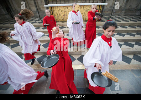 Les Choristes à partir de la cathédrale d'Ely dans le Cambridgeshire pratiquer pour ce qui est de la course de crêpes années lieu le Mardi Gras ( Feb 13) dans la cathédrale. Les Choristes ont été occupés à pratiquer pour la traditionnelle course de crêpes à la Cathédrale d'Ely dans le Cambridgeshire demain (mardi). Les filles, vêtus de leurs soutanes rouges, perfectionné leurs compétences pour lancer de crêpes l'événement annuel dans la Cathédrale du xiie siècle. Chaque année autour de 20 choristes de la Boys' and Girls' choirs dévalez la nef après la messe à l'occasion de Mardi Gras. Il est le troisième plus long nef au Royaume-Uni, mesure 75 mètres. Banque D'Images