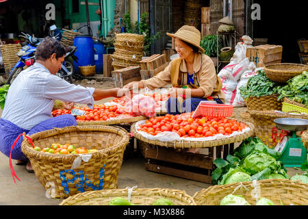 Une femme vend les tomates et le chou à la production de légumes dans les rues de la ville Banque D'Images