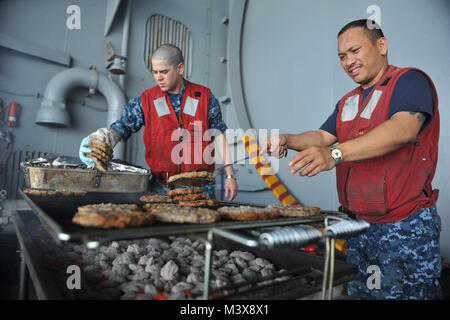 PUGET SOUND, dans l'État (31 juillet 2014) Chef principal spécialiste en logistique Dante M. Castillo, de Bremerton, dans, droit, et Spécialiste du personnel Chef Jose M. Montano, de Cleveland, N.M., cuire des hamburgers pour un pique-nique sur la plage d'acier à bord du porte-avions USS Nimitz (CVN 68) au cours d'une croisière d'une journée de la famille et amis. Nimitz est retourné à la Station Navale Everett après avoir accueilli plus de 400 amis et membres de la famille au cours d'une croisière d'une journée. (U.S. Photo par marine Spécialiste de la communication de masse de la classe 3ème Eric M. Butler/libérés) 140731-N-UV347-022.jpg par l'USS NIMITZ (CVN 68) Banque D'Images