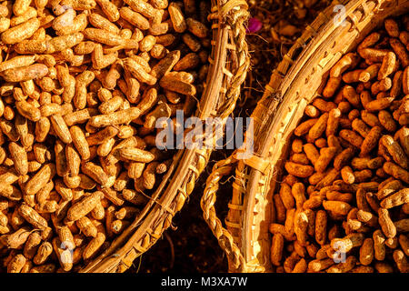 Arachides, emballés dans des paniers en bambou, sont en vente au marché de légumes dans les rues de la ville Banque D'Images