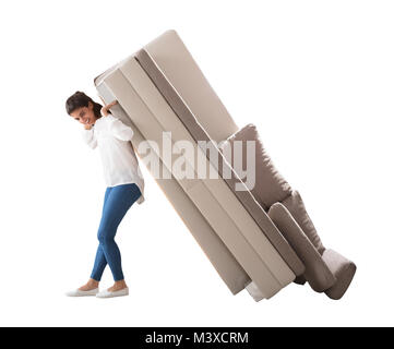 Vue latérale d'un Young Woman Lifting canapé sur fond blanc Banque D'Images