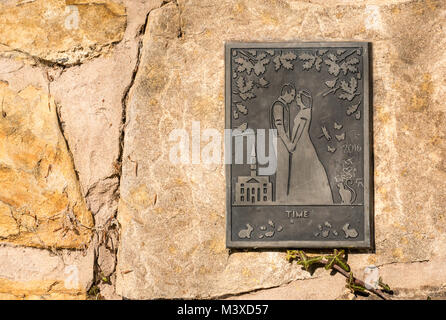 Gros plan de plaque de laiton sur le mur représentant un couple amoureux le jour de leur mariage Banque D'Images