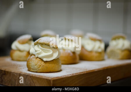 Les jours gras traditionnel bun - semla sur une planche à découper, saupoudrés de sucre. Banque D'Images