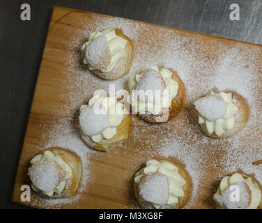 Les jours gras traditionnel bun - semla sur une planche à découper, saupoudrés de sucre. Banque D'Images