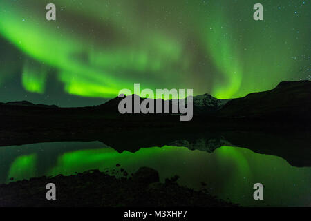 Aurora vert lumière derrière le Lac de montagne en Europe Islande Parc national de Skaftafell Banque D'Images