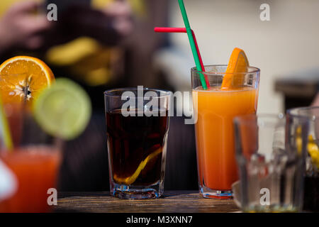Orange et l'alcool Daiquiri cocktail cuba libre sur beach bar table rustique en bois. Banque D'Images
