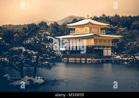 Belle saison d'hiver du pavillon d'or de Temple Kinkakuji avec chute de neige blanche à Kyoto, au Japon, en style vintage. Banque D'Images